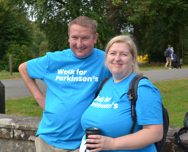 Two people smiling for the camera in Walk for Parkinson's T-shirts