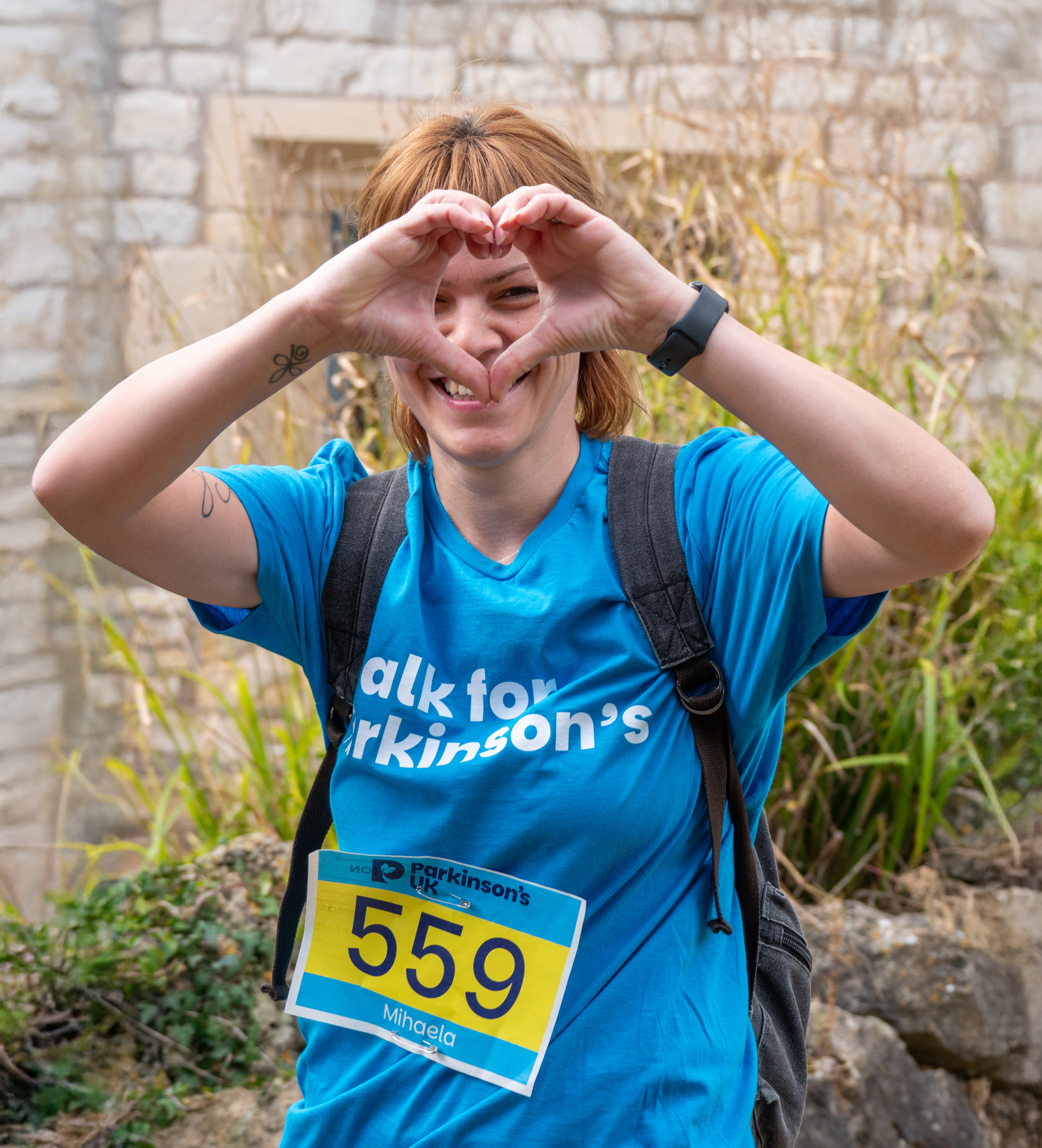 Supporter smiling at the camera doing a heart sign