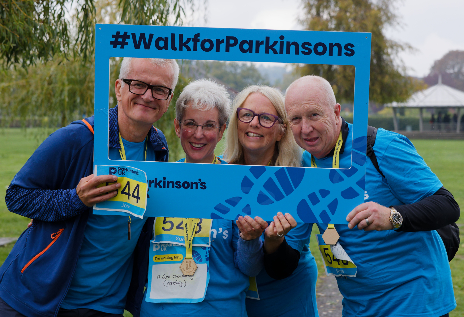 Four people smiling for the camera using a Walk for Parkinson's selfie frame