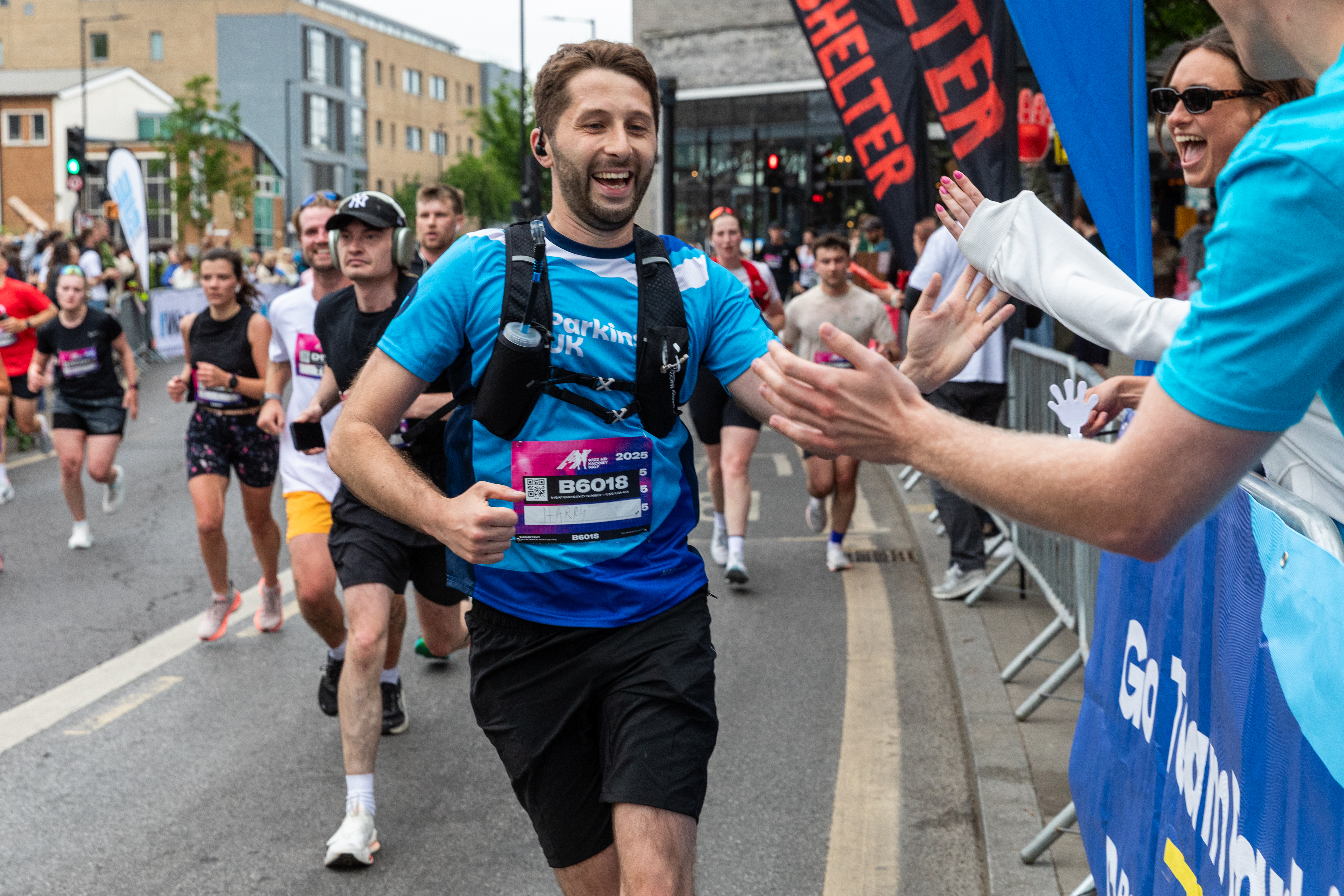 Runner smiling and high fiving the crowd