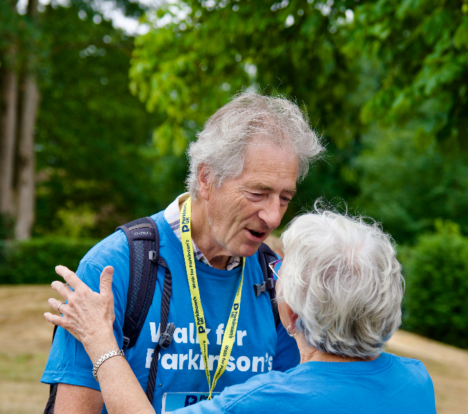 Two people in Walk for Parkinson's T-shirts about to hug